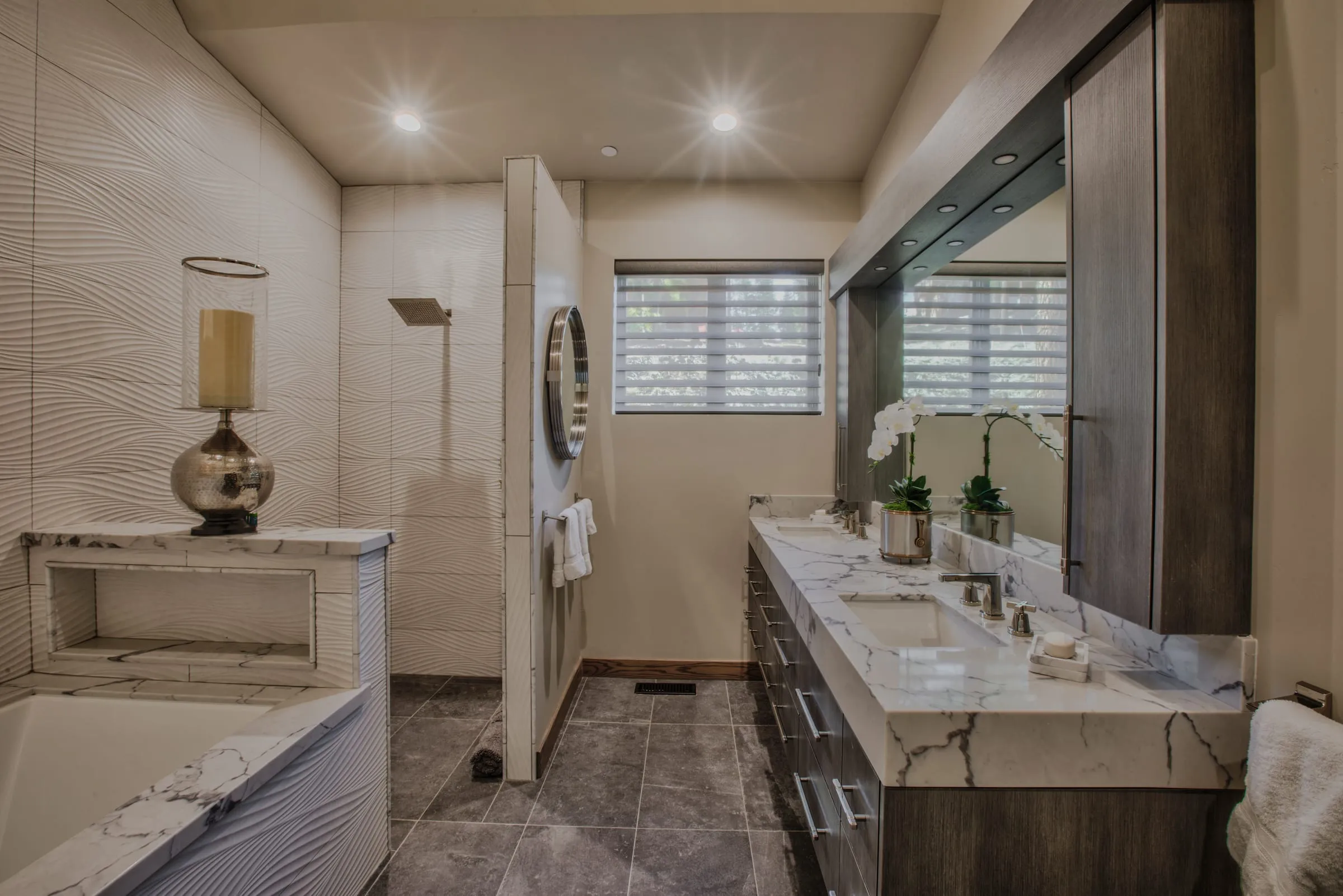 Bathroom with a wave-textured tile wall, a soaking tub, a walk-in shower and a long marble double vanity