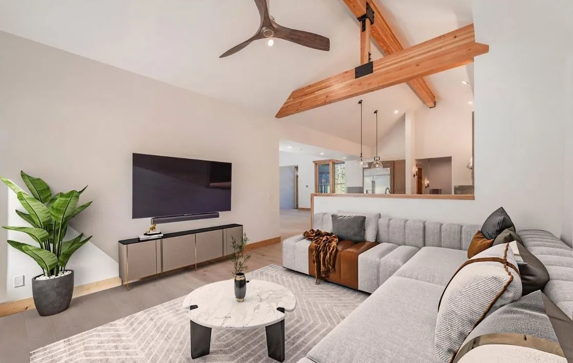 Family room with a vaulted ceiling, an exposed wood beam, a sectional sofa and a pass-through to the kitchen